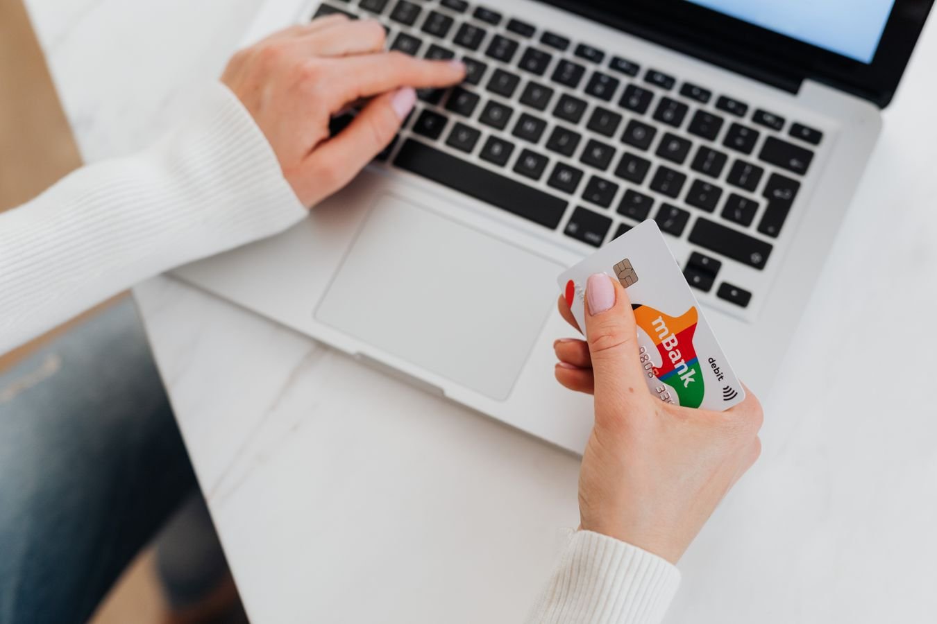 Hand holding a bank card at online checkout, illustrating why cashback didn't track after a purchase