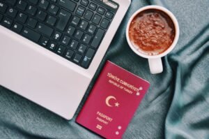 Passport and laptop on a bed, remote work travel setup