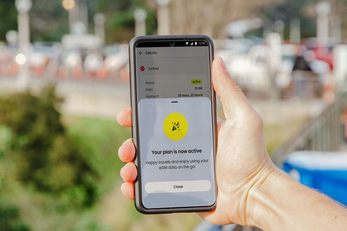Traveler checking whether an eSIM data plan shows as active on a smartphone after fixing a connection problem abroad