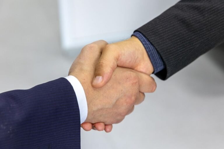 Two professionals shaking hands after a salary negotiation agreement