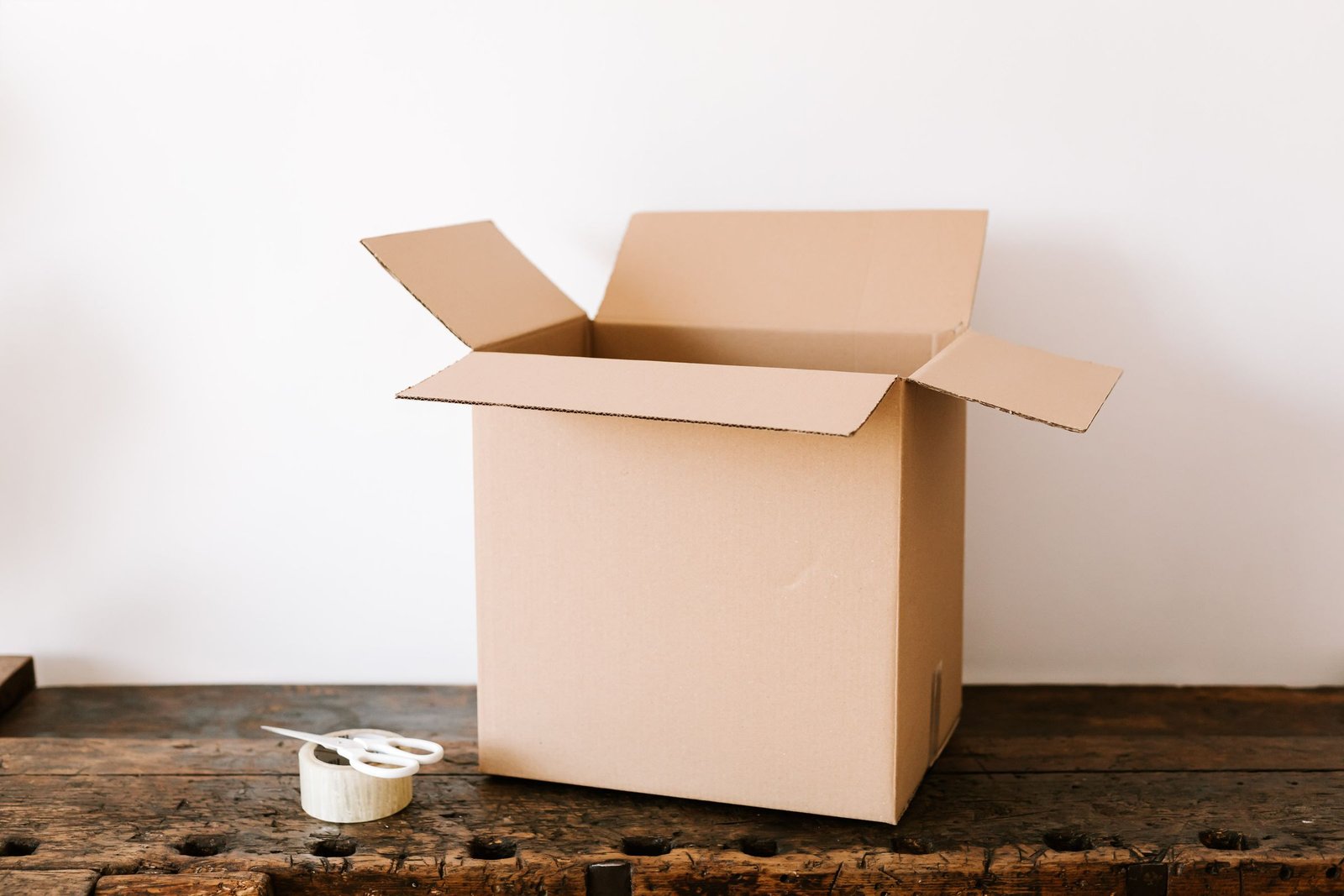Cardboard shipping box with tape and scissors ready for packing a collectible for resale