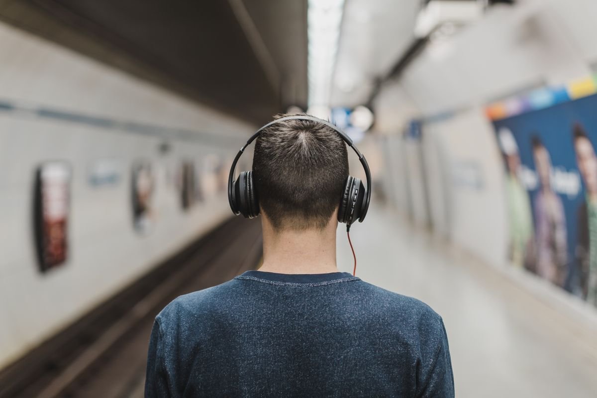Person wearing headphones listening to music, representing catching up on comebacks later