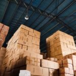 Stacked cardboard boxes in a warehouse, representing international package forwarding and consolidation