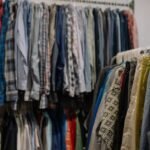 Racks of secondhand clothing sorted for resale, representing apps used to sell used clothes online
