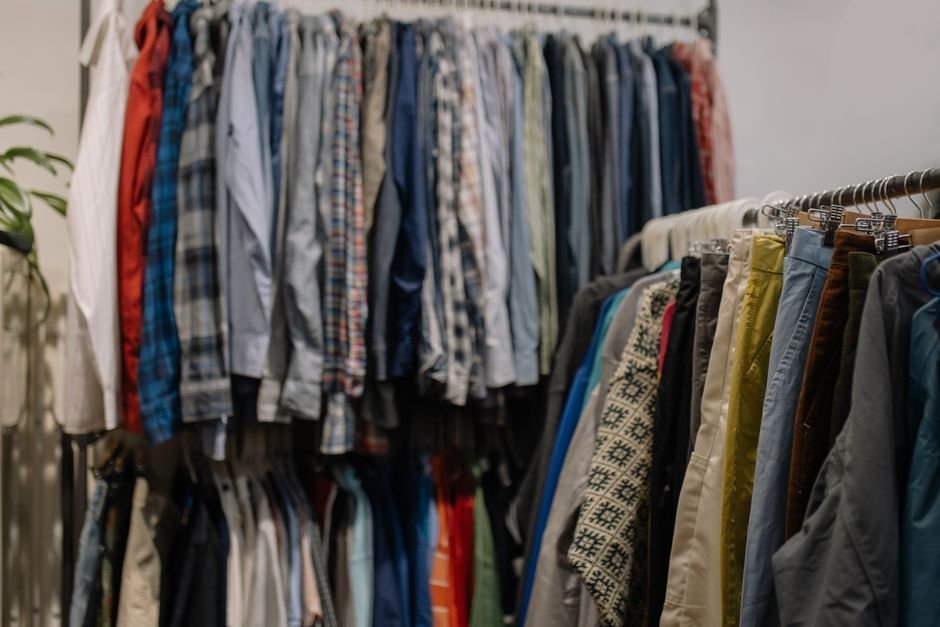 Racks of secondhand clothing sorted for resale, representing apps used to sell used clothes online