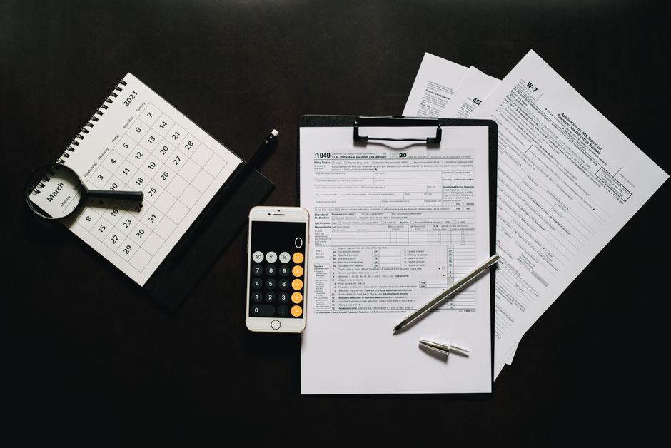 Tax forms, a calculator and a calendar laid out for side hustle tax planning in 2026