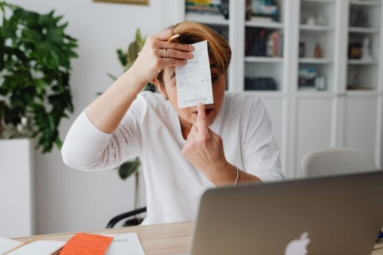 Freelancer reviewing an invoice on a laptop, representing 1099 income reporting for side hustles