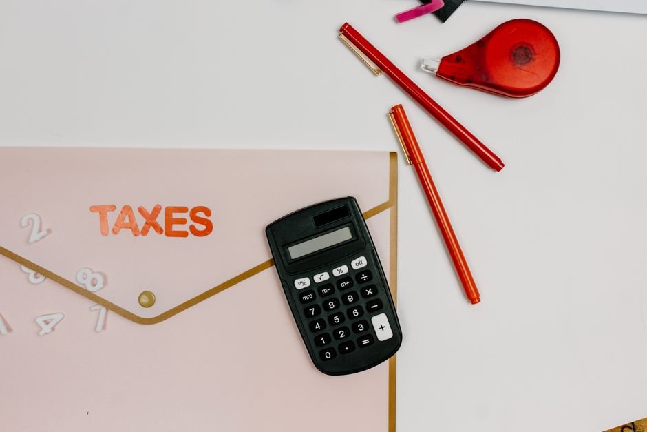 Tax documents and a calculator, representing comparing 1099-NEC and 1099-K reporting thresholds