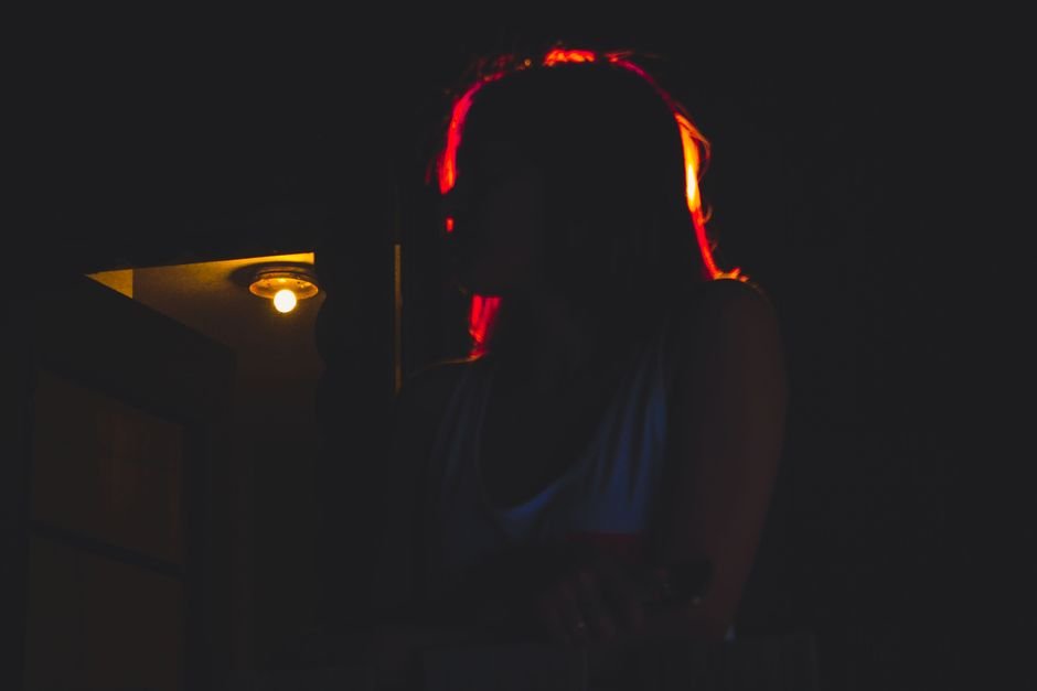 Dramatic silhouette of a woman in a dark setting, representing a hidden double life