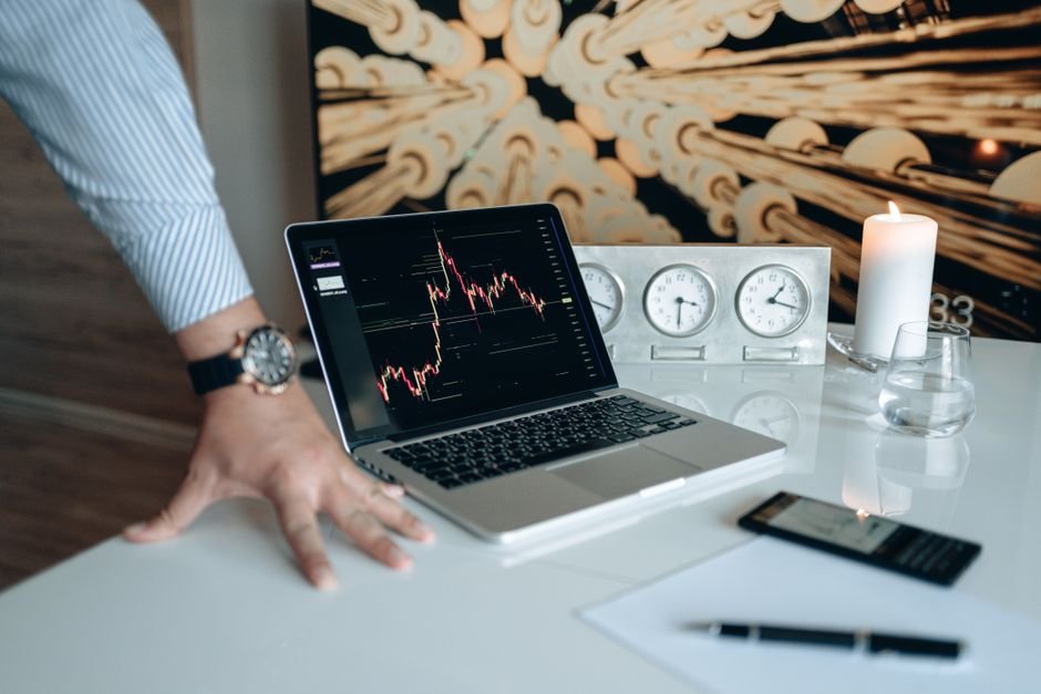 Desk workspace with a laptop displaying a stock chart, used to check earnings guidance