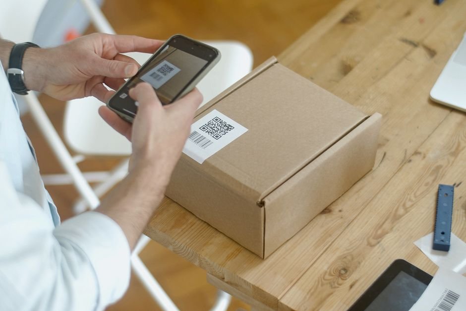 Person scanning a QR code on a package with a smartphone