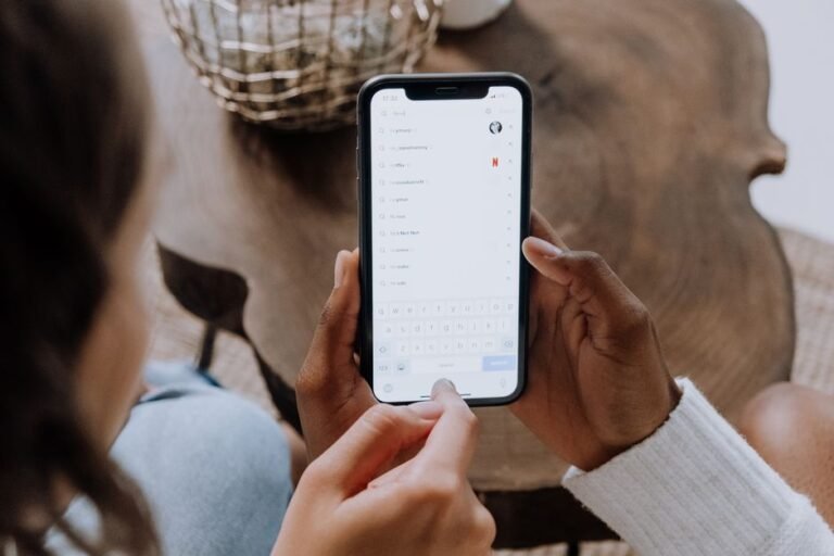 Person holding a smartphone while checking a subscription app settings screen