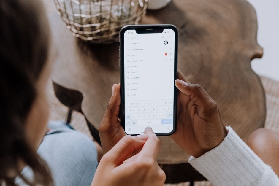 Person holding a smartphone while checking a subscription app settings screen