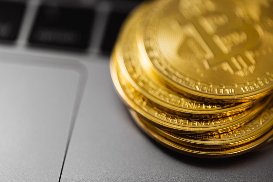 Stack of Bitcoin coins resting on a laptop keyboard, symbolizing crypto holdings exposed to 2026 hacks