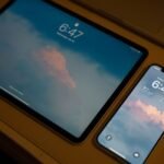 Smartphone and tablet showing matching lock screens, representing devices staying in sync
