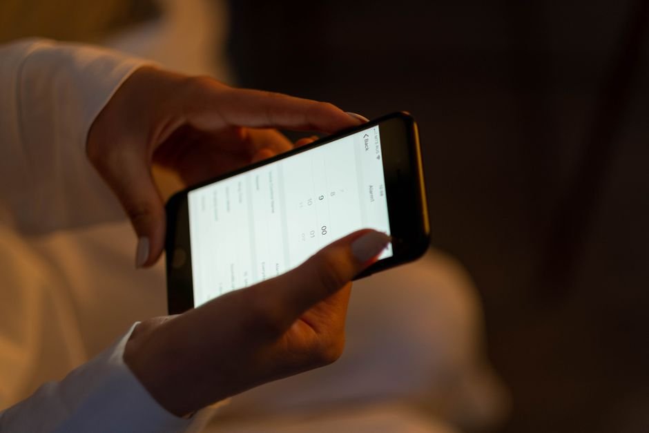 Hands adjusting settings on a smartphone at night