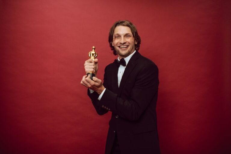 Person in formal attire holding an award trophy, representing music award nominations