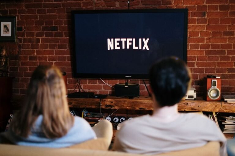 Couple relaxing on a couch streaming a show together, representing a Netflix K-drama watch night