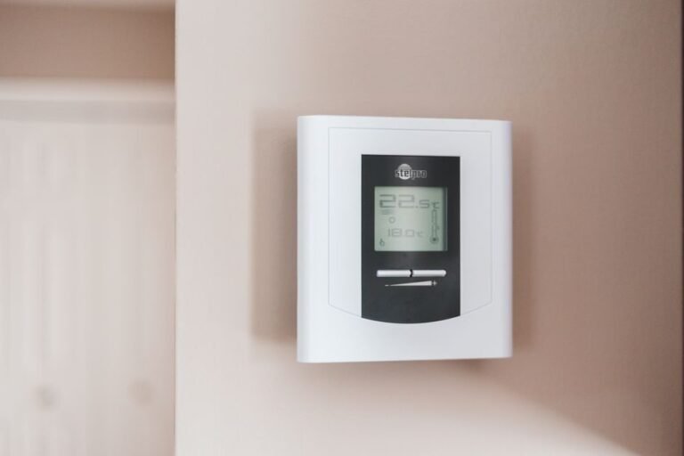 Close-up of a digital smart thermostat mounted on a wall