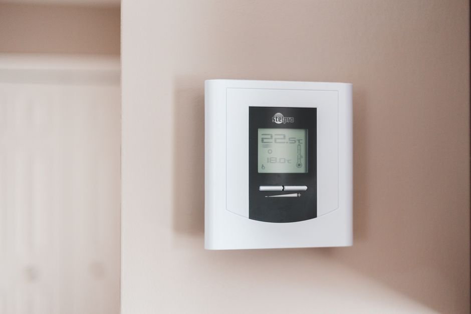 Close-up of a digital smart thermostat mounted on a wall