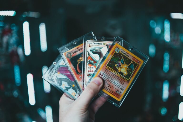 Hand holding a stack of Pokemon trading cards being reviewed before grading submission