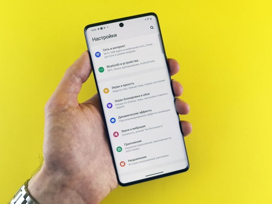 Hand holding a smartphone with a settings menu open, representing app troubleshooting steps
