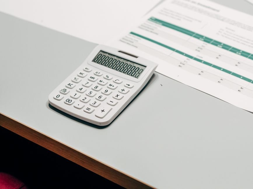 Calculator next to a spreadsheet for estimating AI API cost per task
