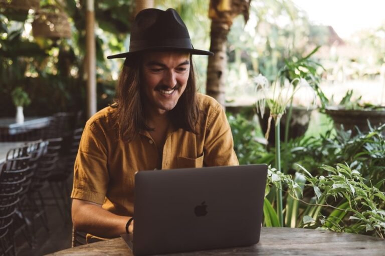 Digital nomad working on a laptop in a tropical outdoor garden workspace in Bali