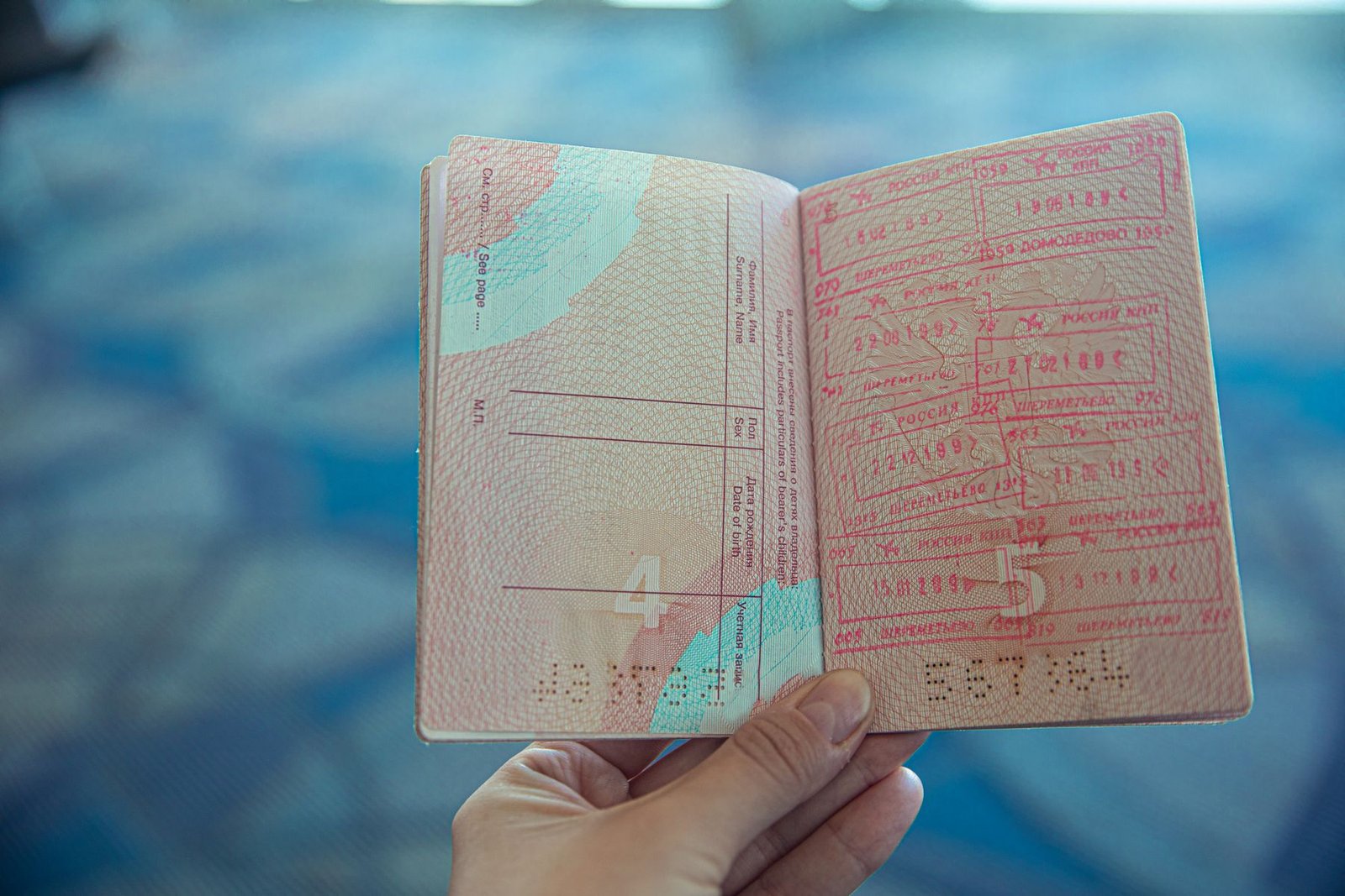 Passport and travel documents on a table with a laptop nearby