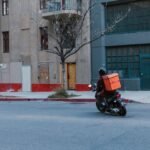 Delivery driver on a scooter representing gig economy delivery work like DoorDash