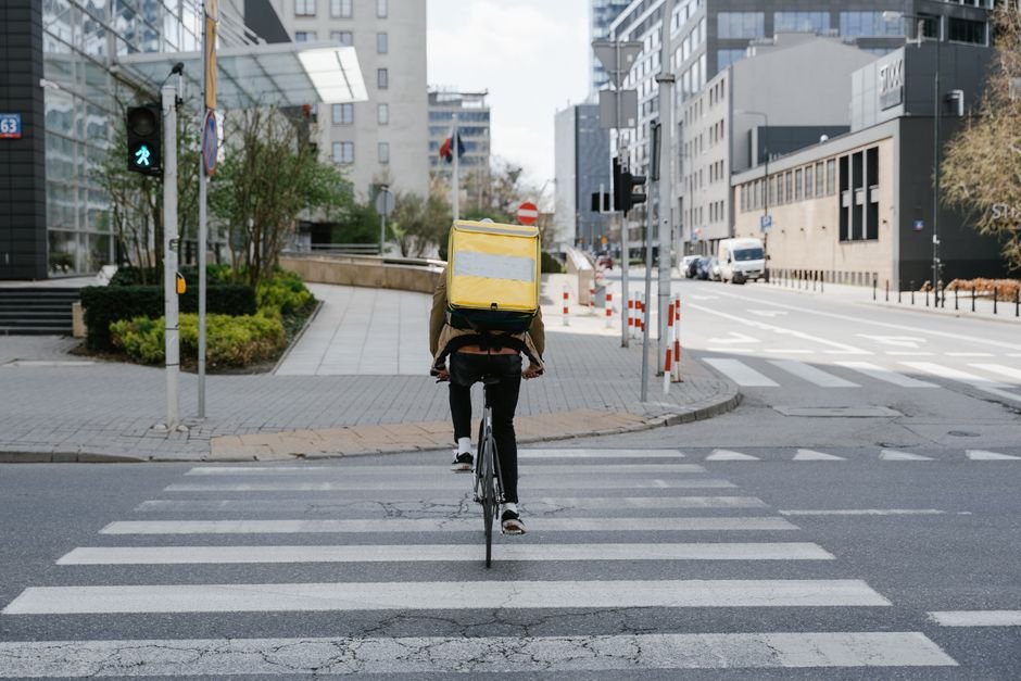 Food delivery courier with an insulated delivery bag on a bicycle