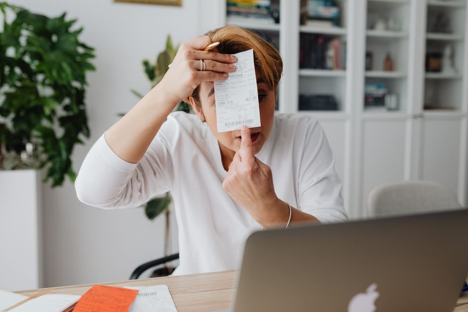 Etsy seller reviewing shop expenses and invoices on a laptop