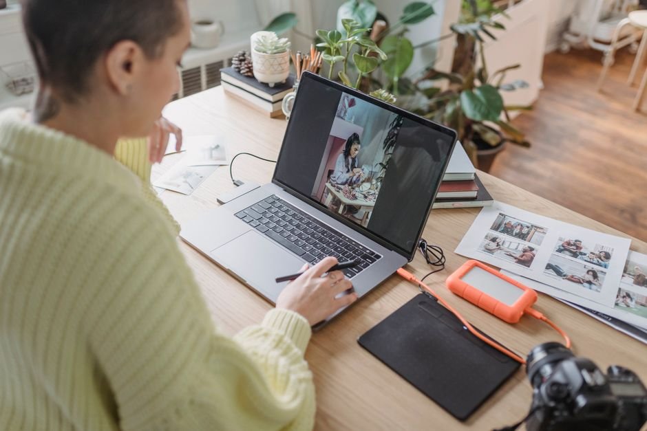 Person editing a photo on a laptop with design software open