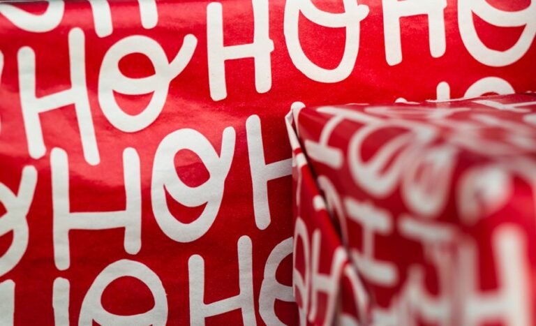 Close-up of hands wrapping a holiday gift