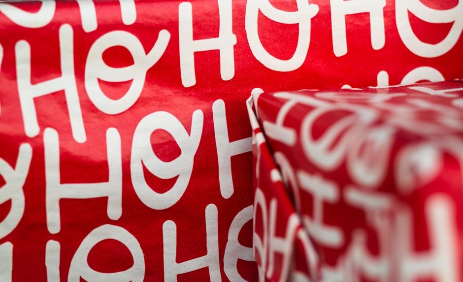 Close-up of hands wrapping a holiday gift