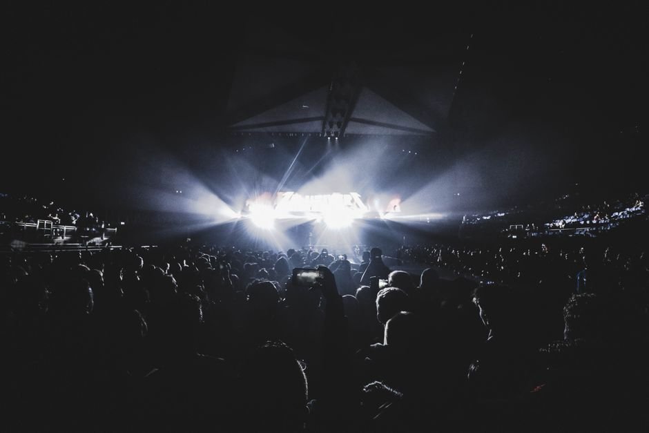 Energetic stadium concert crowd at night, representing BTS ARIRANG World Tour fans at SoFi Stadium