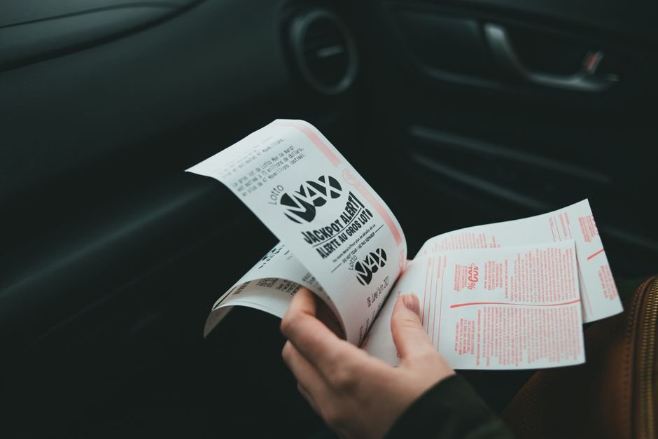 Close-up of a hand holding lottery tickets, symbolizing the jackpot win at the center of the drama's plot
