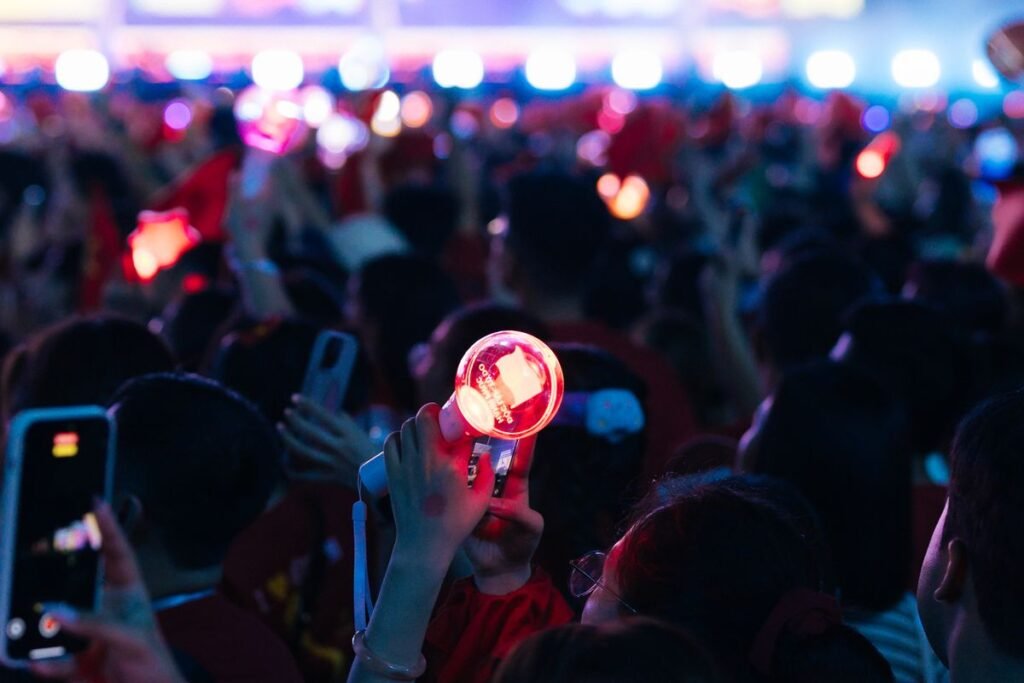 Fans holding lightsticks at a K-pop concert arena