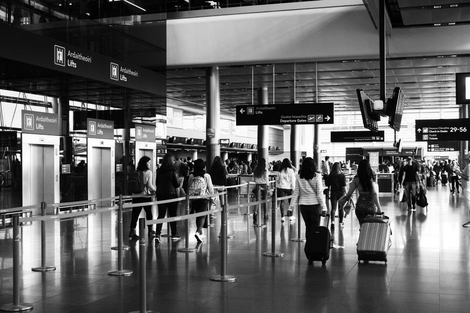 Traveler checking a passport and boarding pass at an airport gate