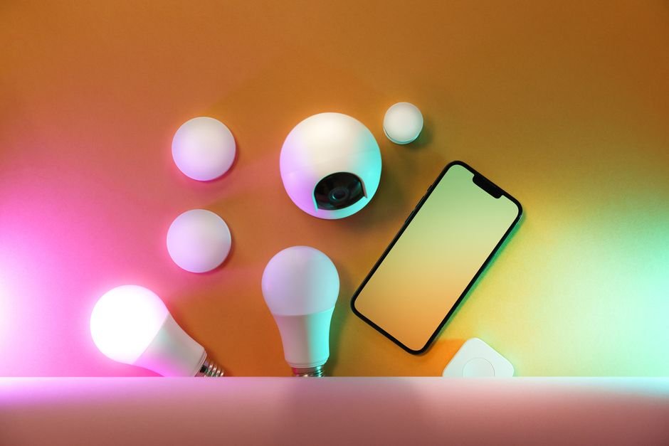 Smartphone next to smart home devices representing app-based control across ecosystems