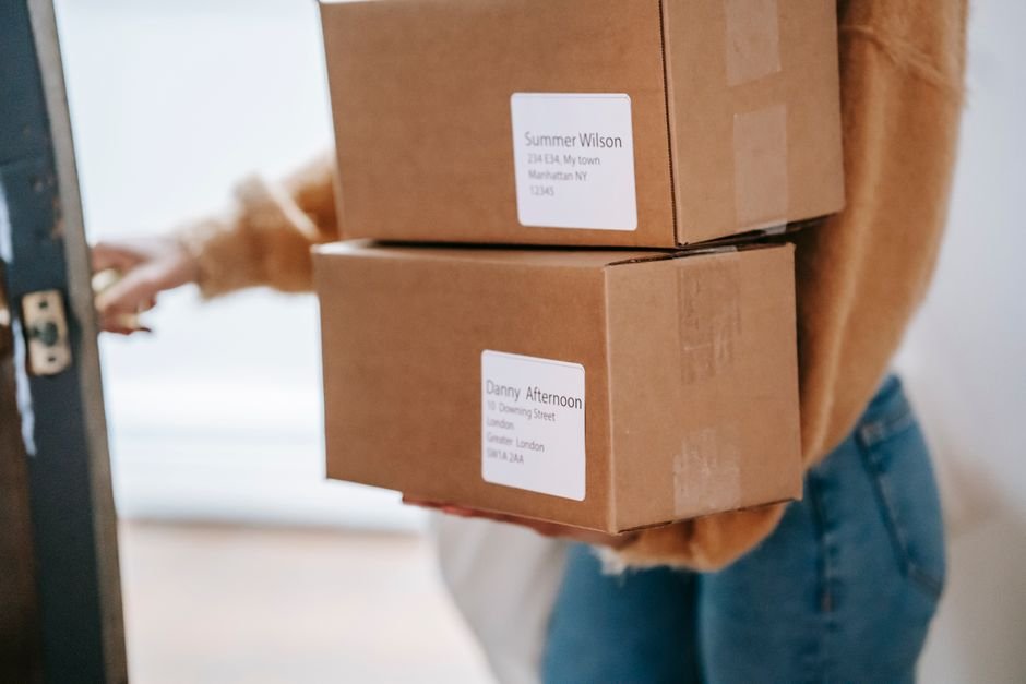 Person carrying addressed parcels into a post office