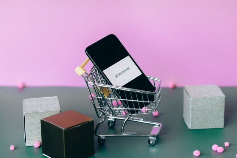 Smartphone with a small shopping cart, illustrating Amazon Auto Buy placing an order automatically at a target price