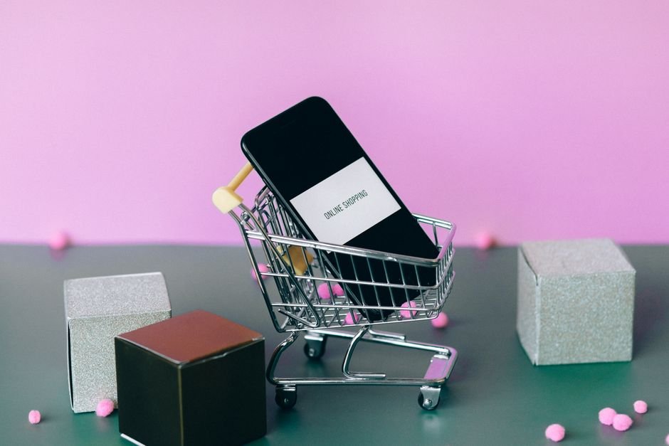 Smartphone with a small shopping cart, illustrating Amazon Auto Buy placing an order automatically at a target price