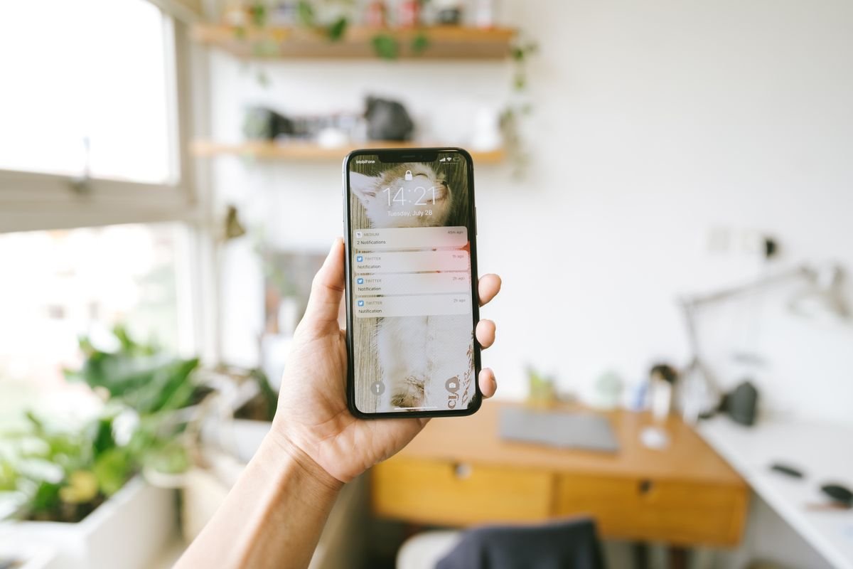 Hand holding a smartphone with notifications, checking for an unfamiliar sign-in