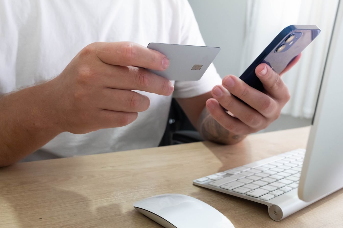 Person holding a credit card and smartphone, the accounts Plaid can link to ChatGPT