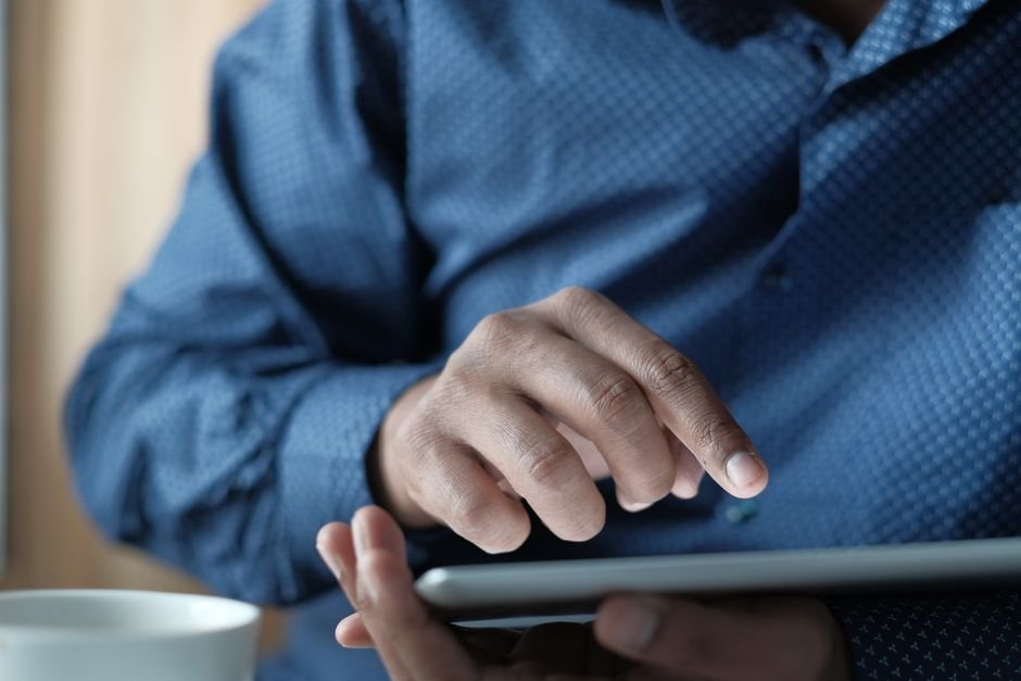 Hands using a tablet indoors, checking the Fire OS version and update status