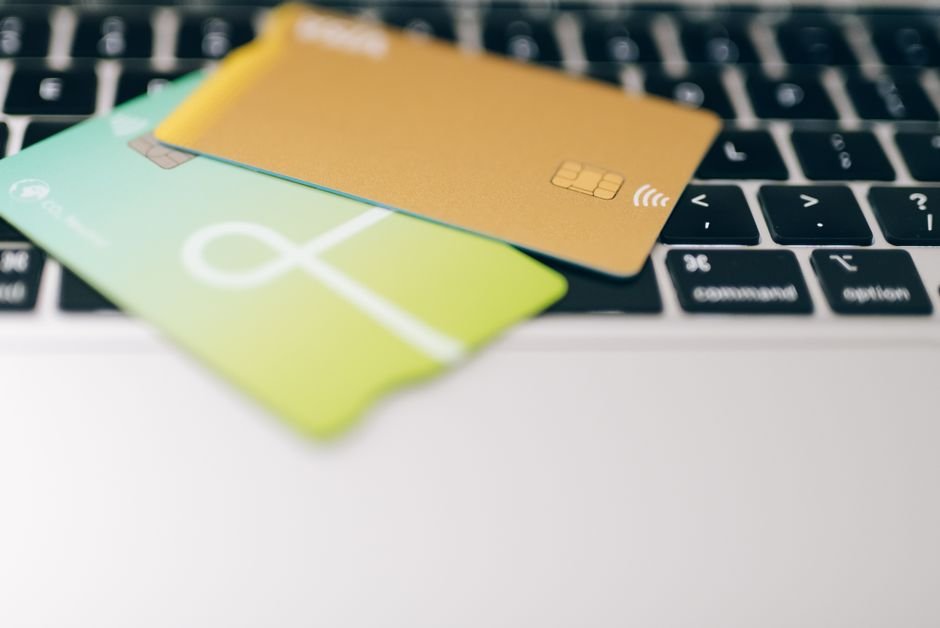 Two credit cards on a laptop keyboard, representing the monthly cost of Google AI Pro versus AI Ultra