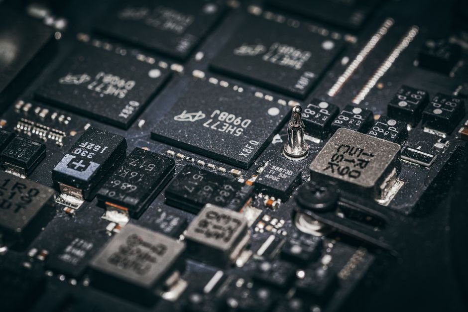 Close-up of microchips on a circuit board, illustrating the hidden cellular implant found in tampered Ledger devices