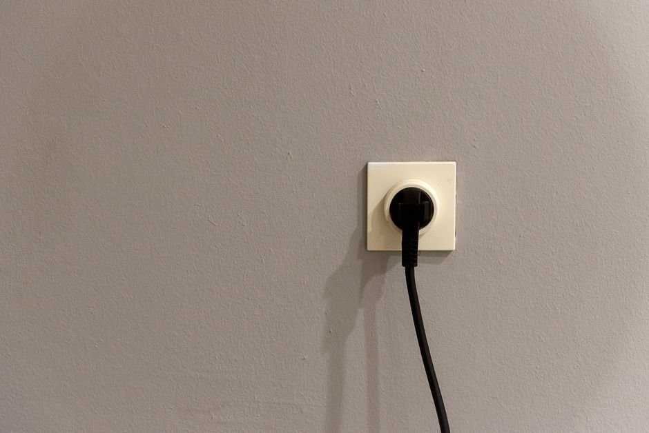 Black plug inserted directly into a wall socket, as CPSC advises for space heaters
