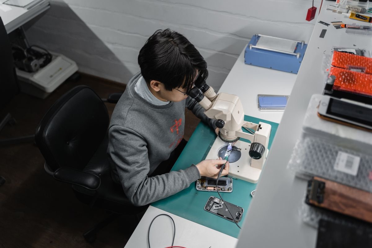 Technician inspecting a smartphone at a repair bench